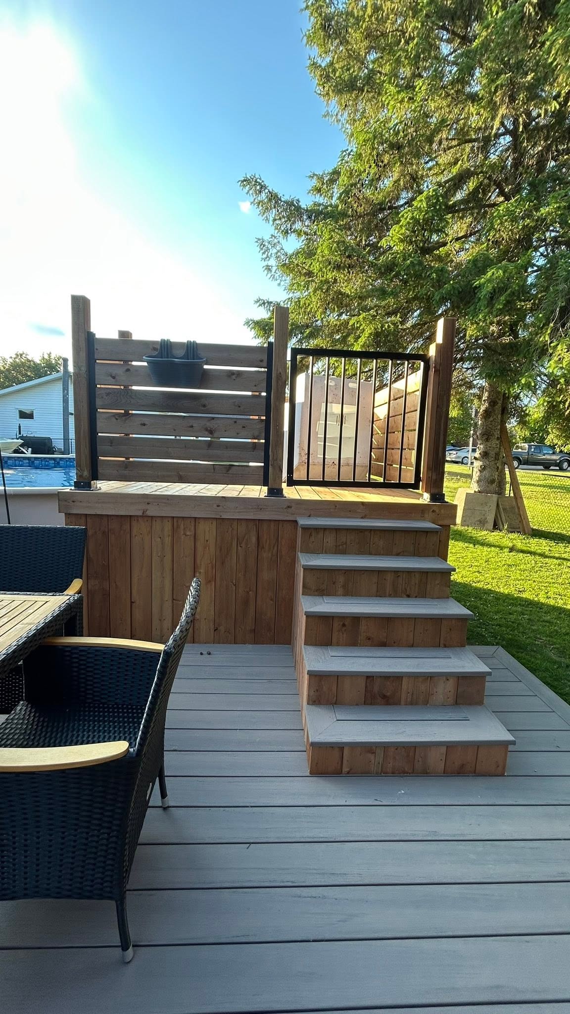 Deck steps with wood trim, railings and a privacy screen.