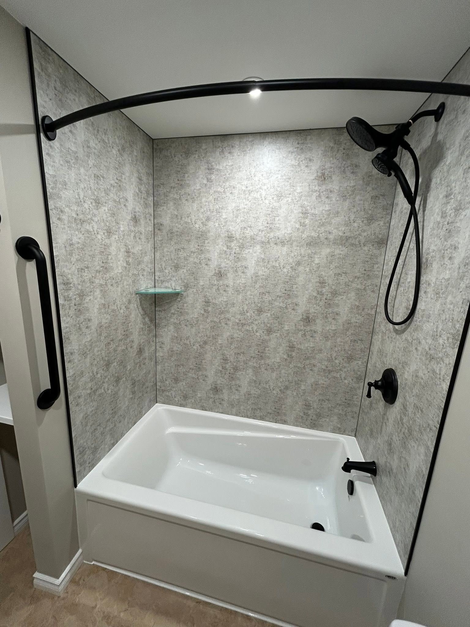 Bathtub surround with dark shower fixtures.